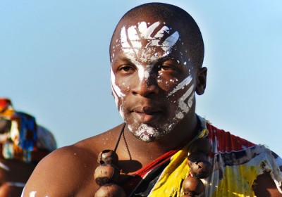 Young man wears traditional clothing during presentation of a Zulu show