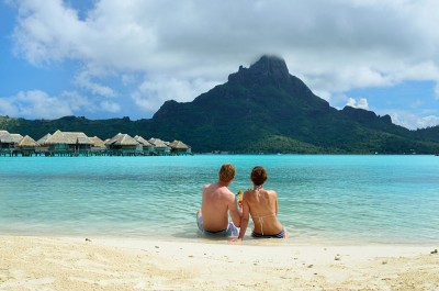 A Couple Drinking a Cocktail on the Beach of a Luxury Vacation Resort With View of Bora Bora, Tahiti