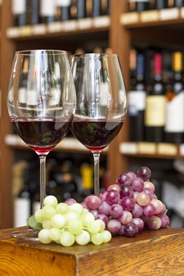 Glasses of Red Wine and Grapes, with Background of Wine Bottles, Mendoza, Argentina