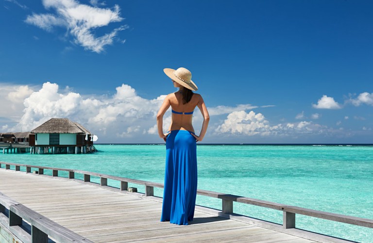 Woman on a Tropical Beach Jetty in the Maldives