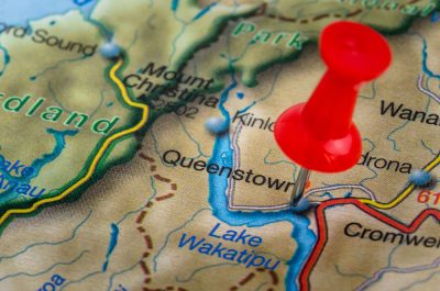Close Up of a Map of New Zealand with a Red Pushpin Highlighting Queenstown