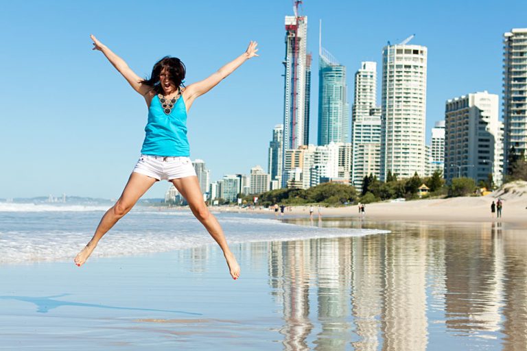 Happy Woman Jumping for Joy on Beach Along the Gold Coast, Queensland, Australia