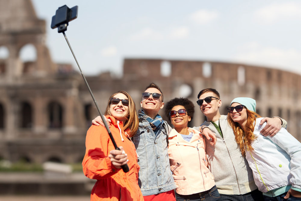 Group travel and sharing a photo at the Coliseum in Rome