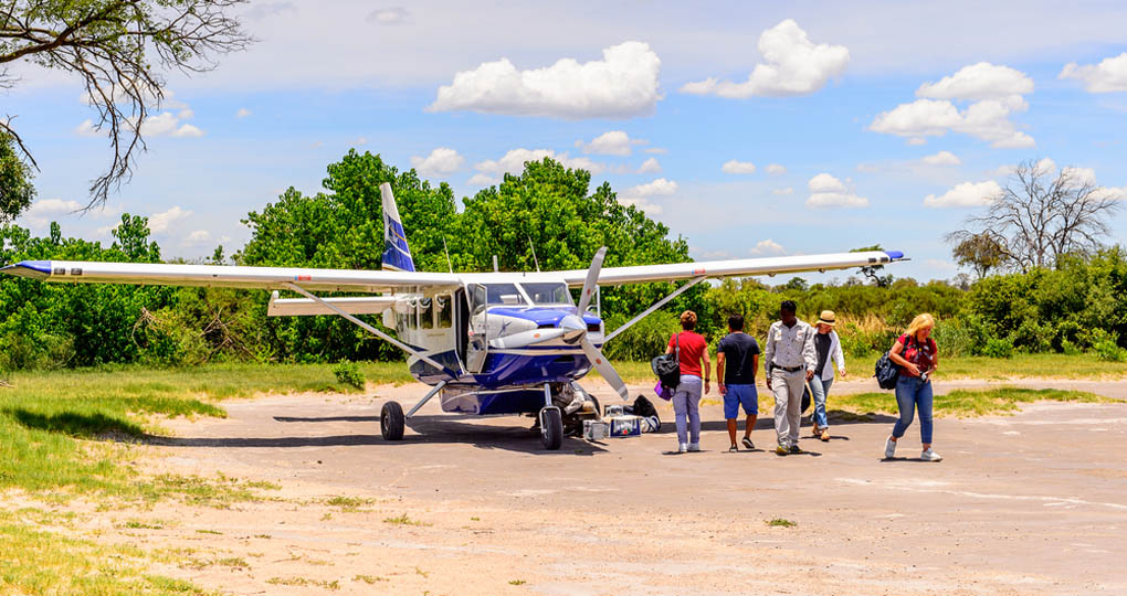 Tourists on an African safari arrive by small plane to the Okavango River Delta National Park in Botswana