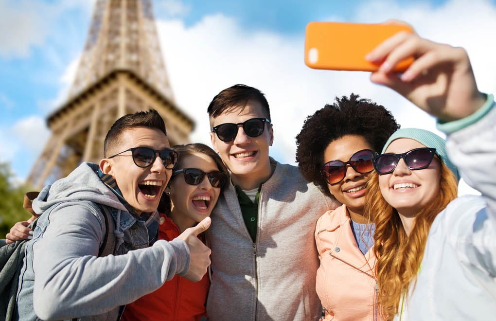 A group of friends taking a selfie in front of the Eiffel Tower in Paris