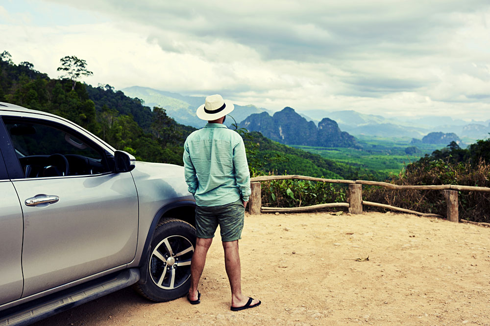 Male Traveller with SUV Admiring Landscape in Thailand