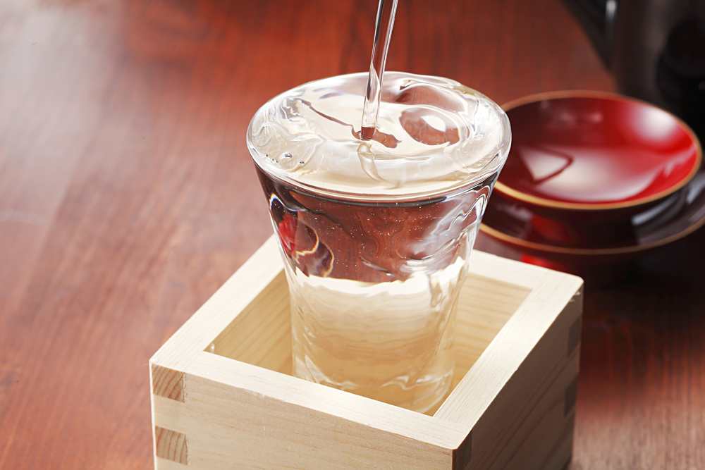 Pouring Japanese Sake in Glass Over a Masu, Japan