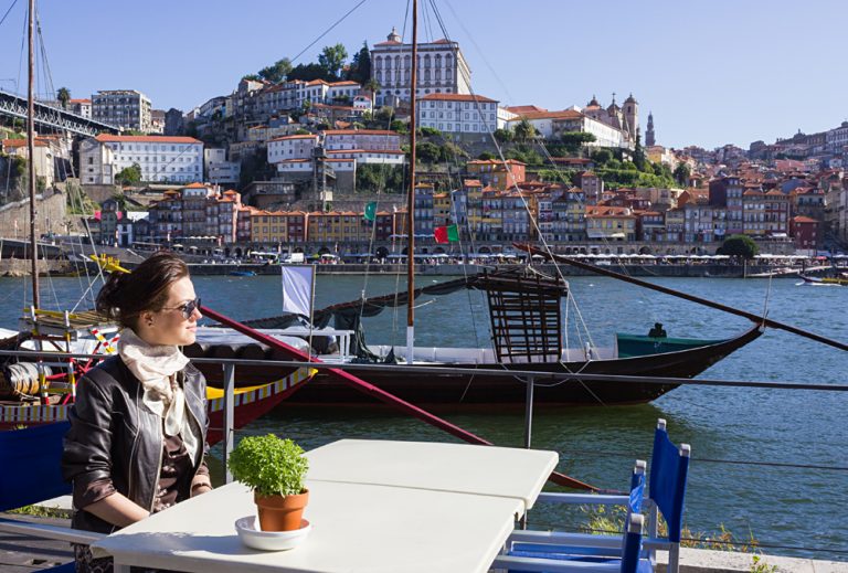 Young Woman Sitting in a Cafe on the Banks of the River Douru, Porto, Portugal