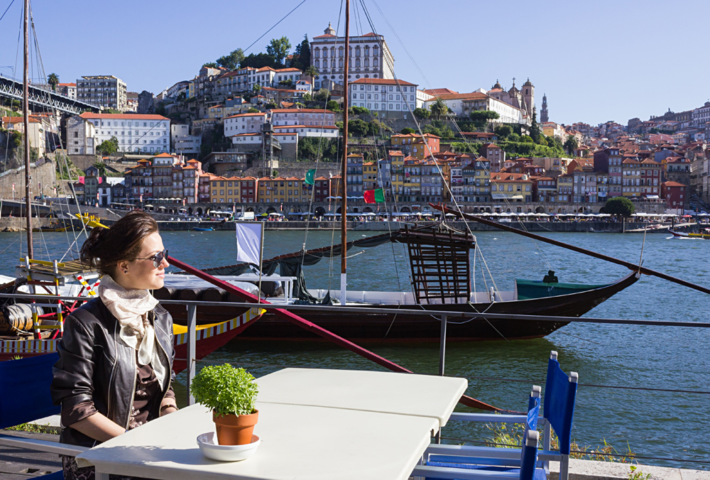 Young Woman Sitting in a Cafe on the Banks of the River Douru, Porto, Portugal