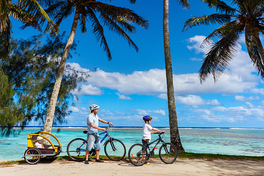 Father and kids biking in Rarotonga, Cook Islands