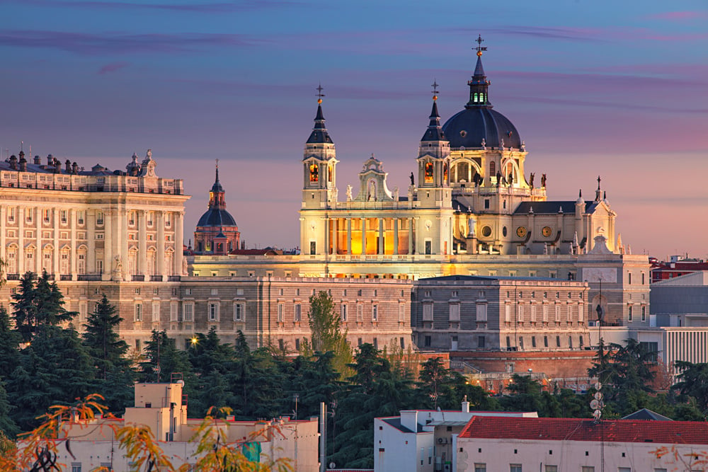 Madrid skyline with Santa Maria la Real de La Almudena Cathedral and the Royal Palace during sunset, Spain