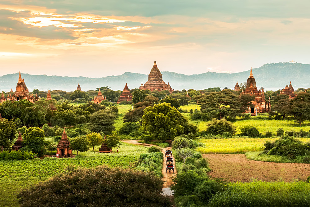 Ancient temples and horse and carriages at sunset in Bagan, Myanmar