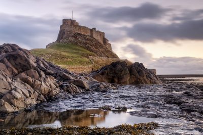 Rugged coastline of Holy Island in Northumberland is protected by Lindisfarne Castle, England, UK (United Kingdom)