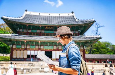 Young woman tourist with map in hand with Asian architecture, Seoul, South Korea