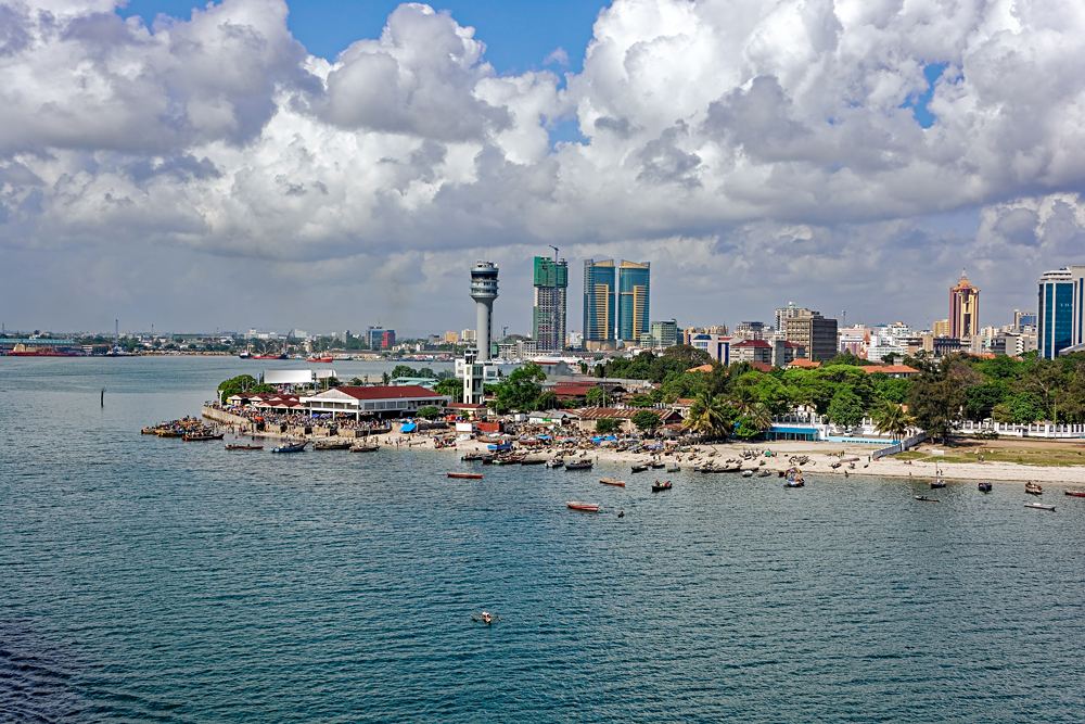 Fisherman boats in front of Kivukoni Fish Market with Port control tower and Skyscrapers in Background, Dar Es Salaam, Tanzania