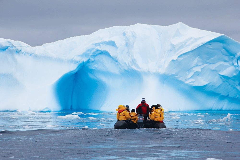 Men on Zodiac witnessing stunning ice formations in Antarctica