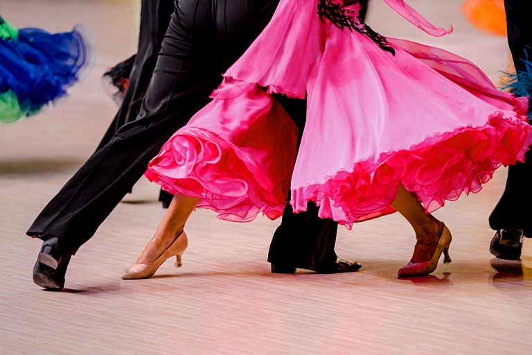 Ballroom dancers in black tailcoat and pink ball gown