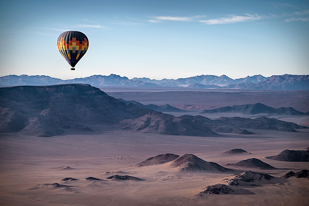 Colourful hot air balloon flying over the high mountains in Namibia