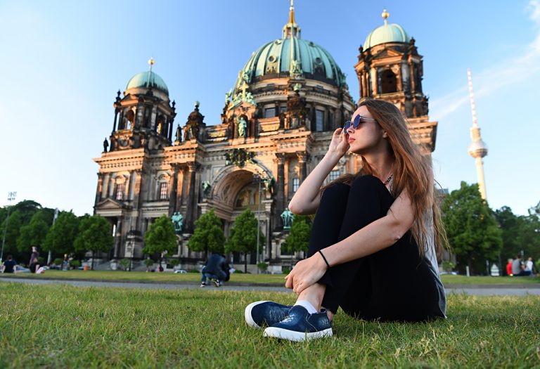 Woman sitting in front of Berlin Cathedral at beautiful sunset, Berlin, Germany