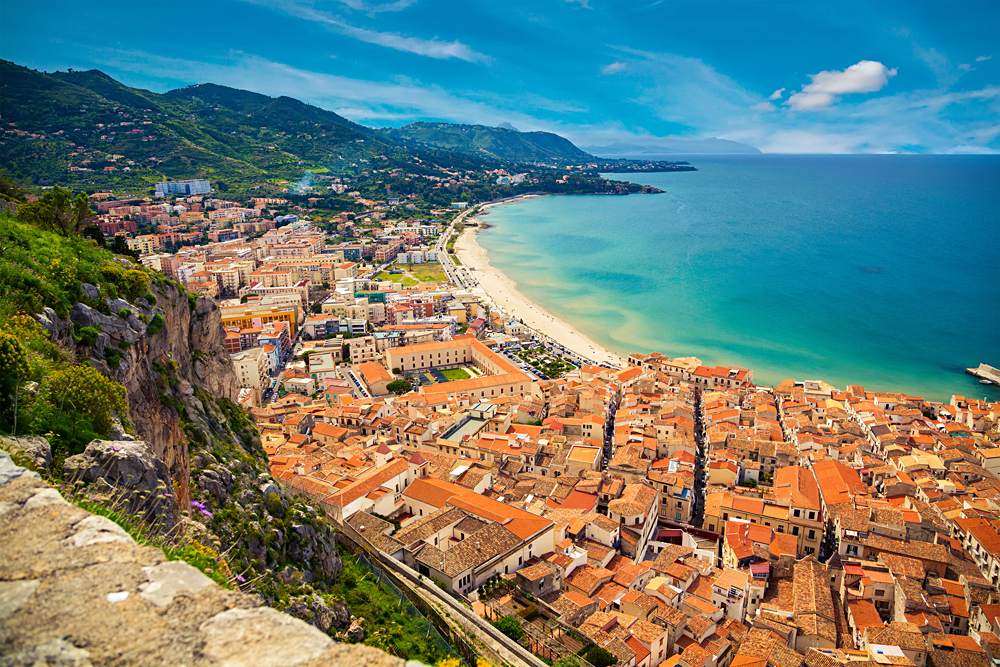 Upper view of bright orange roofs near the sea in Cefalu, Sicily, Italy