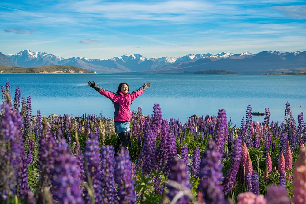 Woman traveller at lake Tekapo in the summer, New Zealand