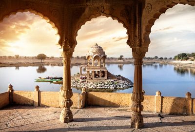 Arches and temple in Gadi Sagar lake at sunset sky in Jaisalmer, Rajasthan, India