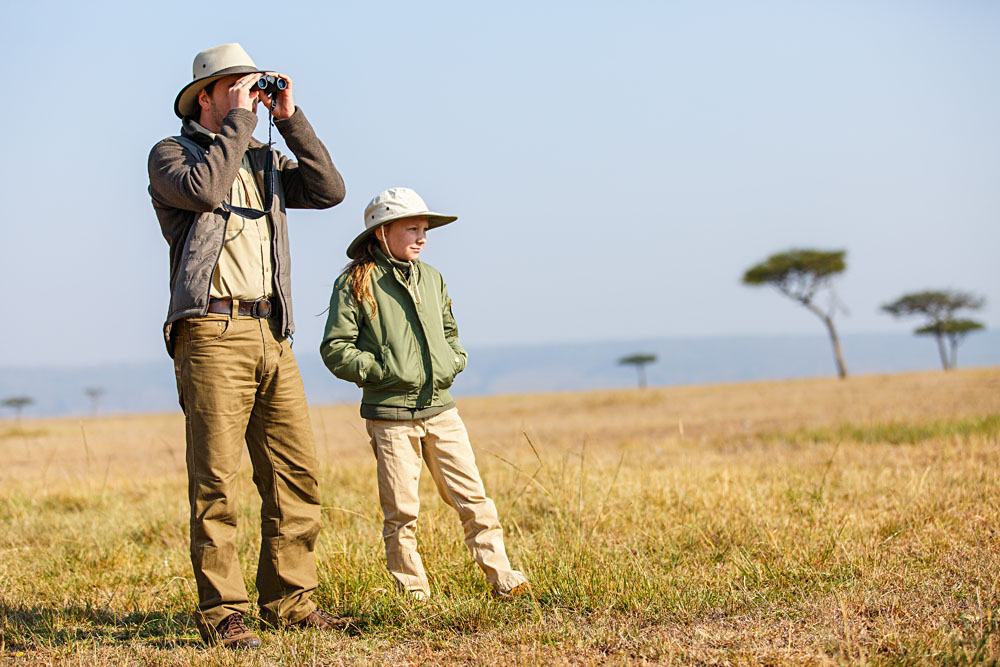 Father and child on African safari vacation enjoying bush view