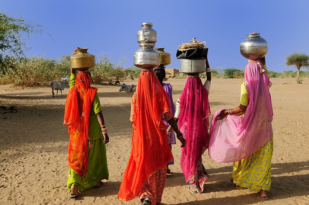 Ethnic women going for water in well in Thar Desert near Jaisamler, Rajasthan, India