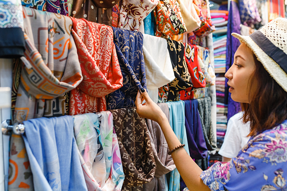 Young Woman Shopping For a Scarf in Bazaar