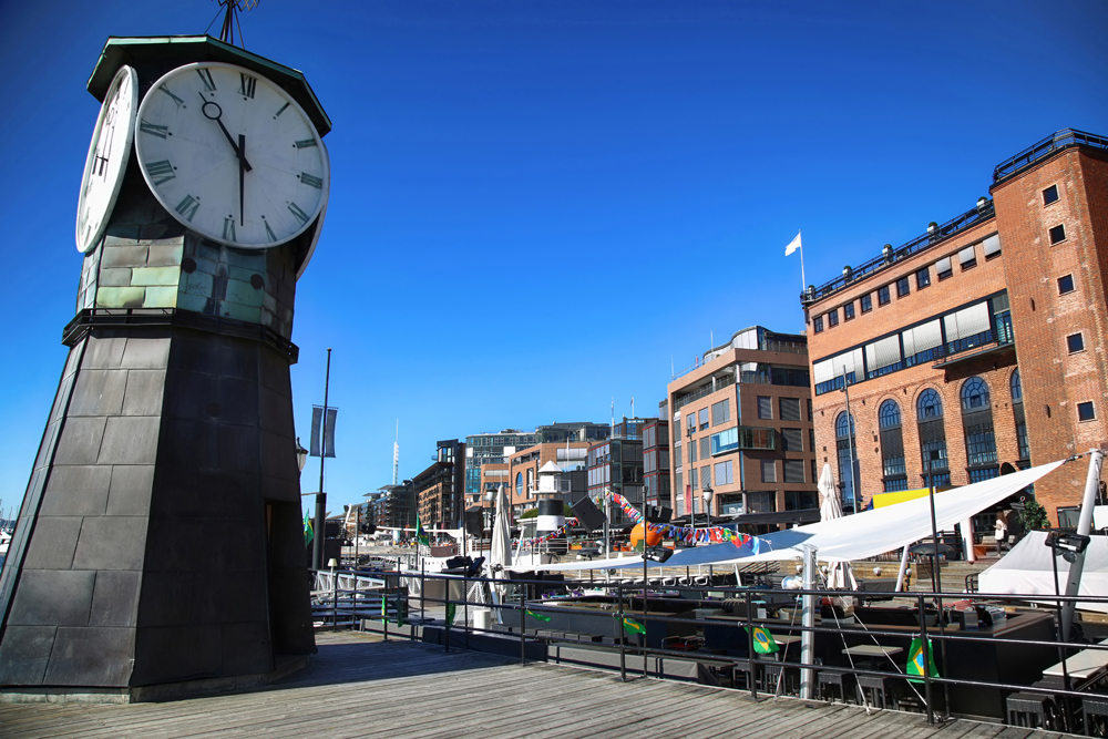 Clock tower on Aker Brygge dock and modern buildings, Oslo, Norway 