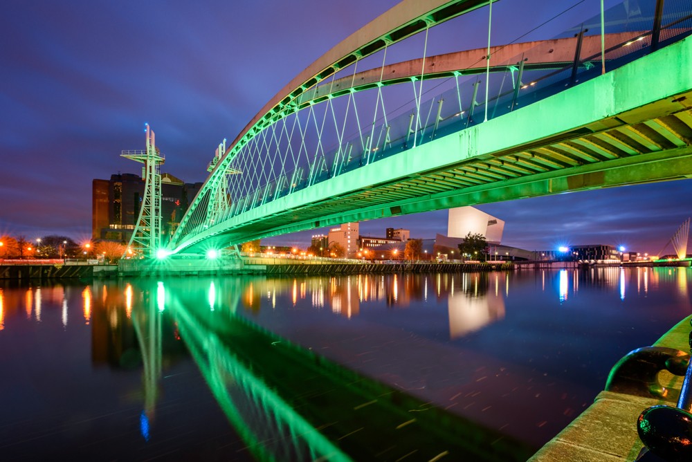 Illuminated Millennium Bridge over the Manchester canal in Salford Quays, Manchester, England, UK 