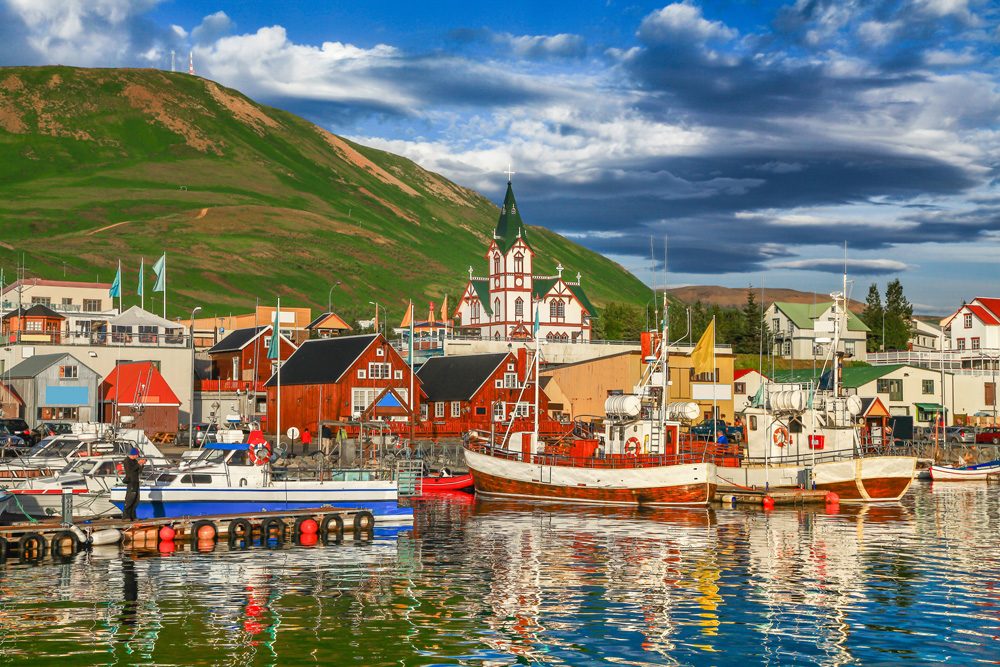 Historic town of Husavik and its harbour at sunset, northern coast of Iceland 