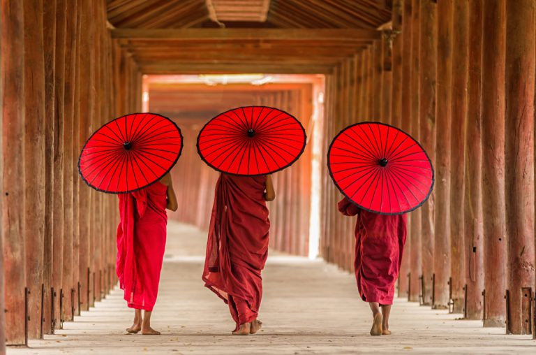 Three Buddhist monks walking in temple, Bagan, Myanmar