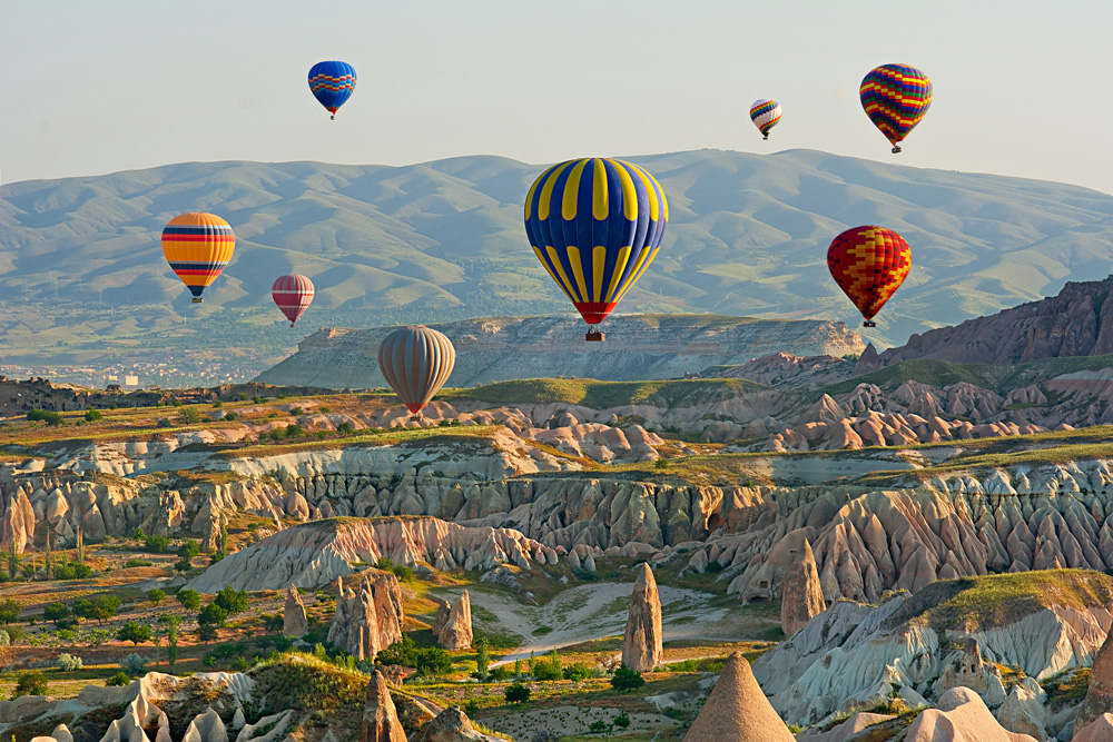 Colourful hot air balloons flying over the valley at Goreme National Park, Cappadocia, Turkey 
