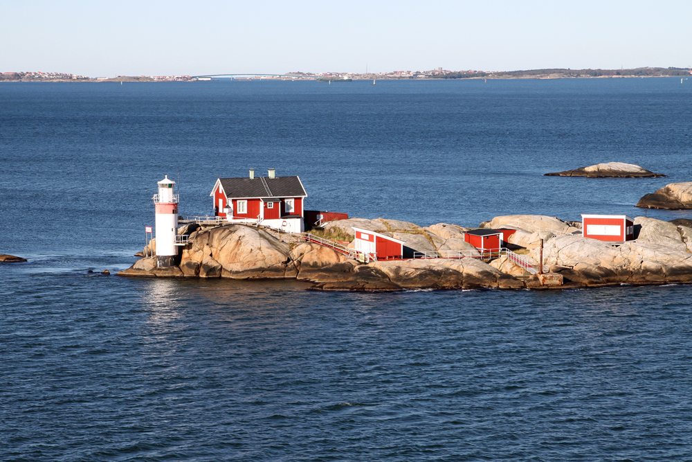 Lighthouse and red buildings on small rocky island in Gothenburg archipelago on the North Sea, Sweden 