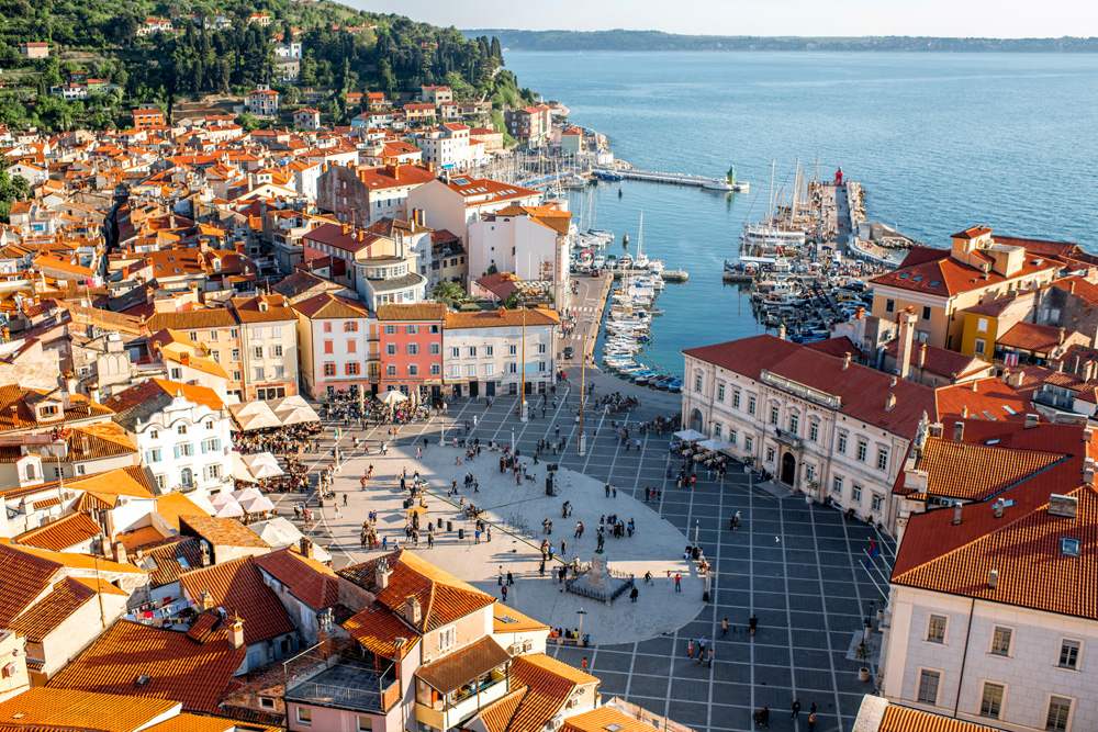 Aerial view of Piran with Tartini Square, ancient buildings with red roofs, and Adriatic Sea, Slovenia 