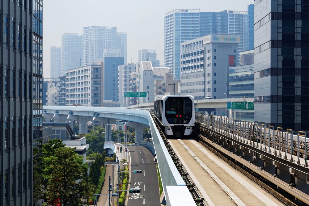 Metro train travelling on elevated rails of Yurikamome Line near Takeshiba Station in downtown Tokyo, Japan 