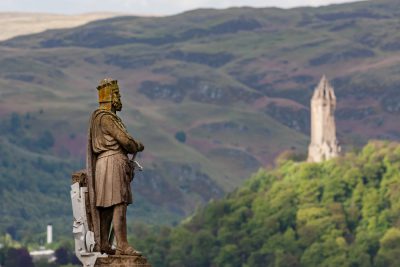 Statue of King Robert I (Robert The Bruce), with National Wallace Monument in background, Stirling, Scotland