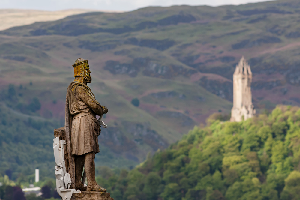 Statue of King Robert I (Robert The Bruce), with National Wallace Monument in background, Stirling, Scotland