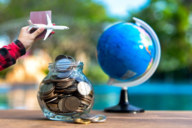 Travel savings in a glass jar with dreams of globetrotting - budget concept