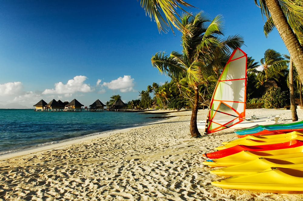 Colourful kayaks rest on Matira Beach, Bora Bora, Tahiti (French Polynesia) Tour