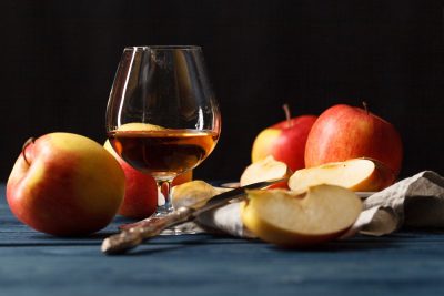Glass of Calvados (apple brandy) and red apples 
