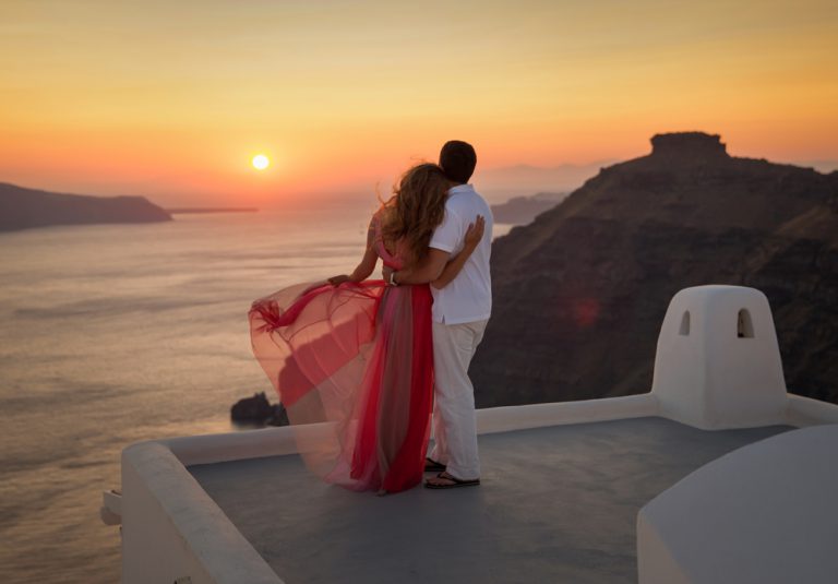 Silhouette of a loving couple in Santorini at sunset, Greece Holidays