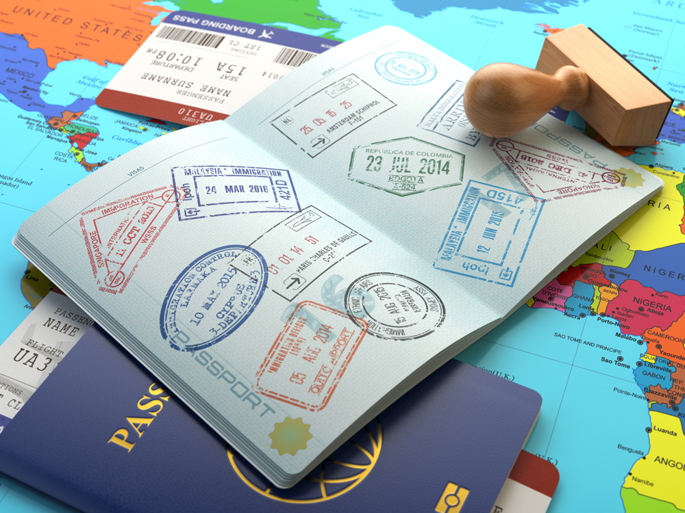 Opened passport with stamps, airline boarding pass tickets and stamper on world map