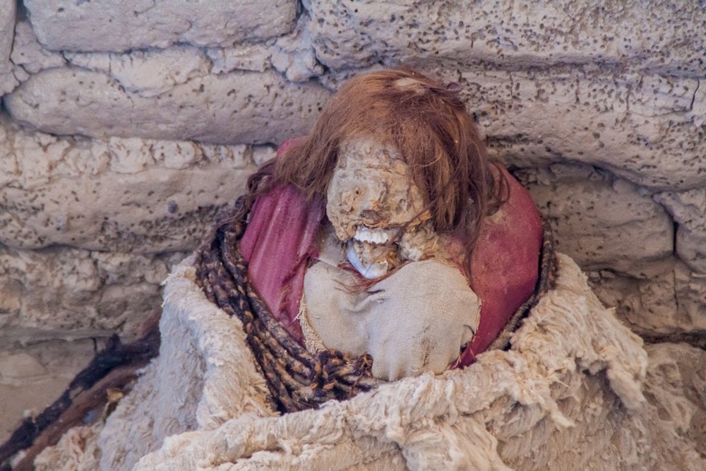 Preserved mummy in a tomb at Chauchilla Cemetery in Nazca, Peru 