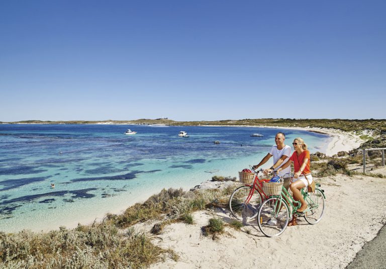 Couple with bikes at Salmon Bay, Rottnest Island, Australia - Tourism Western Australia