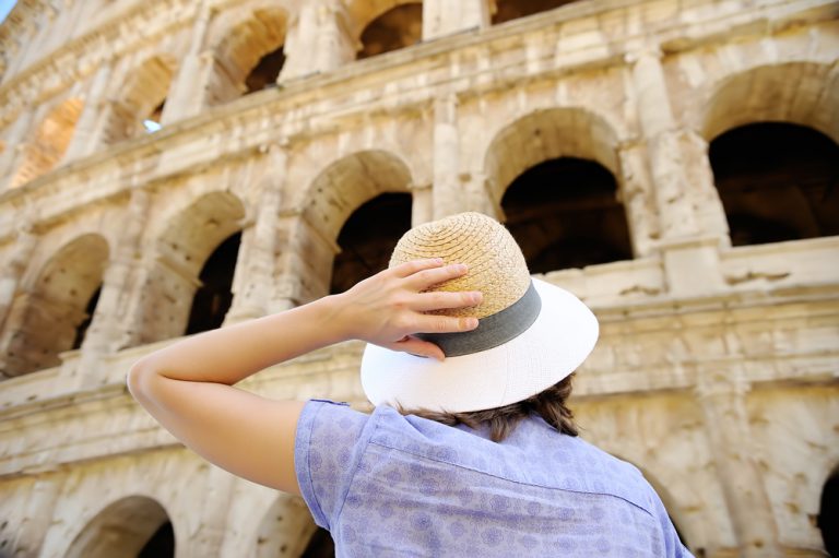 Young female traveller looking at the Colosseum in Rome, Italy