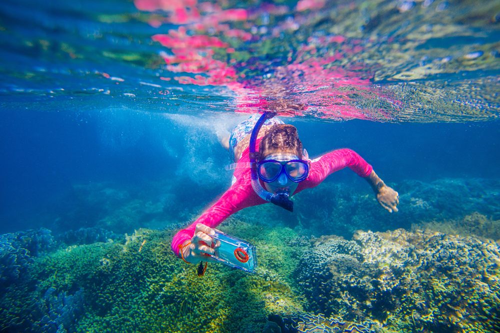 Girl taking pic underwater with waterproof camera 