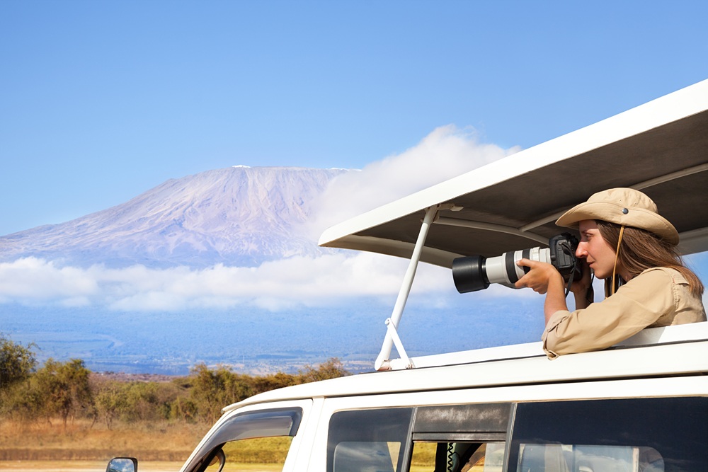 Woman taking shots during Kenyan safari game drive 