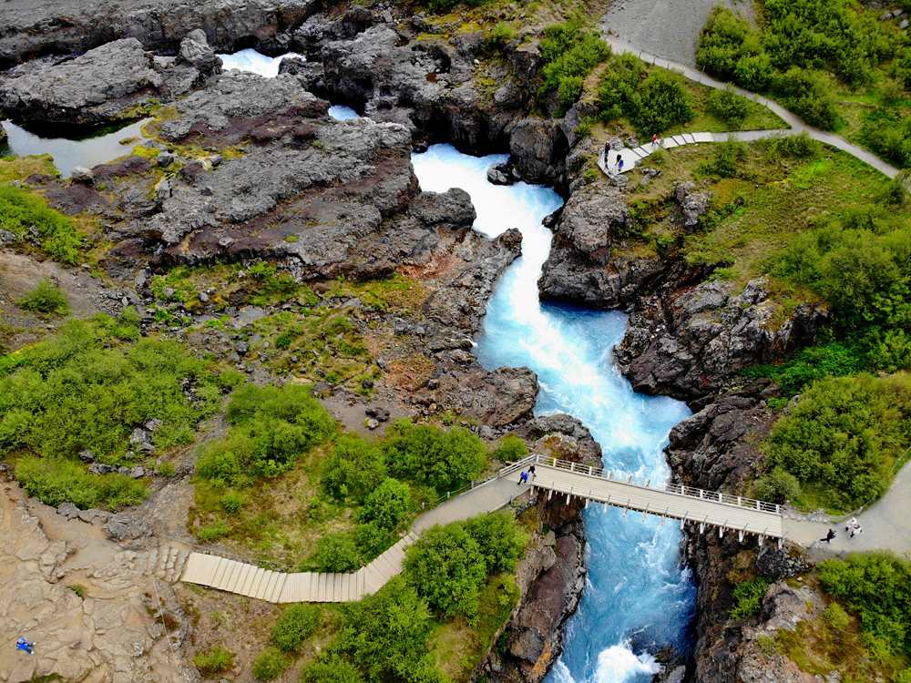 Aerial view of the milky blue river and a bridge near Barnafoss Falls, Iceland 